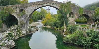 El antiguo puente de piedra de Cangas de Onís cruza con gracia un río tranquilo.