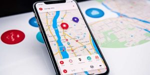 Teléfono móvil encima de un mapa con un app de viajes abierta en pantalla