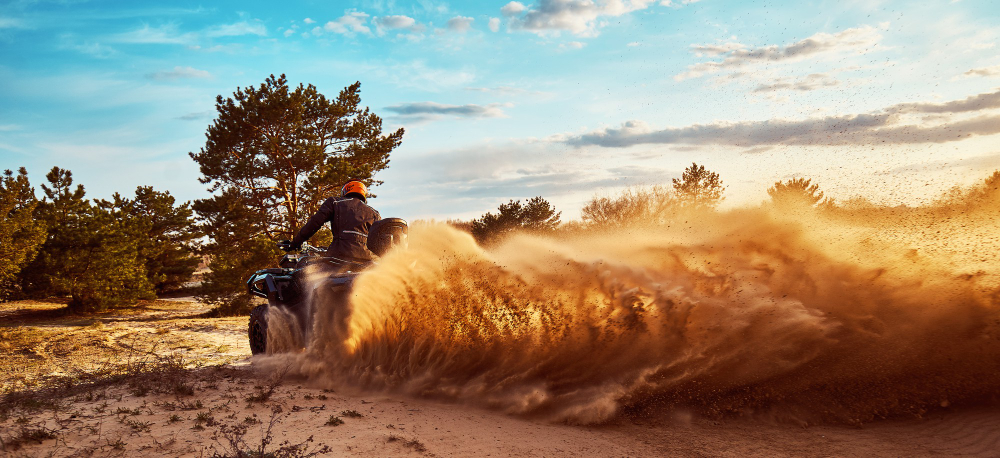 vehículo corriendo por las dunas del desierto y levantando polvareda