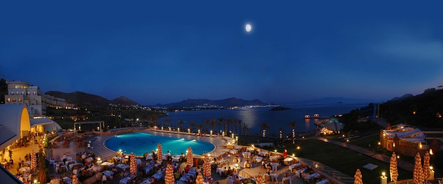 Hotel de lujo, de noche con piscina y la luna de frente