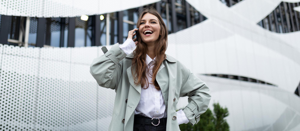 Mujer contenta y sonriente hablando por teléfono
