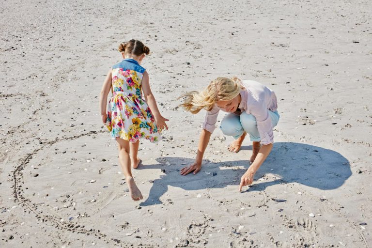 Madre e hija jugando en la playa