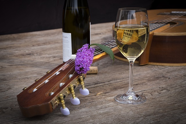 Qué ver en Cádiz: Una copa de vino y una guitarra en una mesa de madera.