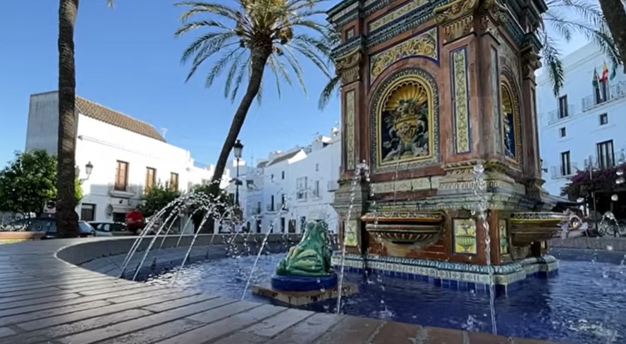 Una plaza con fuente y palmeras en Vejer de la Frontera.