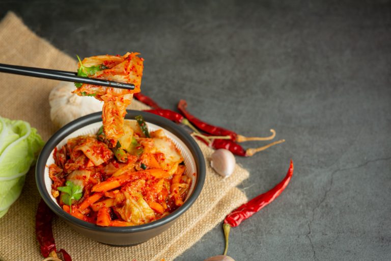 Descripción: Kimchi coreano en un plato con palillos.