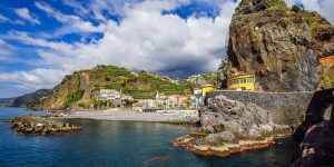 Una costa rocosa con casas y acantilados en Madeira.