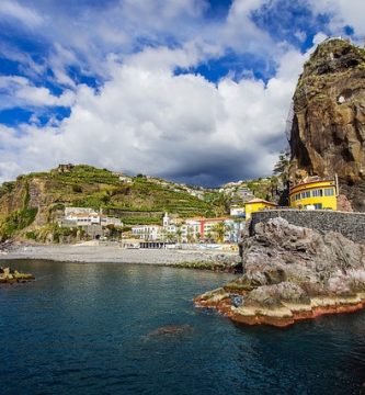 Una costa rocosa con casas y acantilados en Madeira.